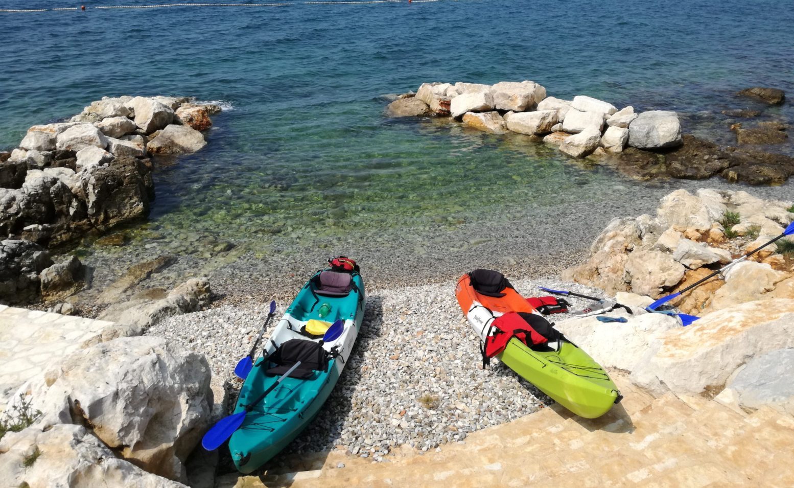 kayaks on a rocky beach in porec croatia