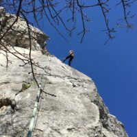 woman climbing cliffs in kalnik croatia